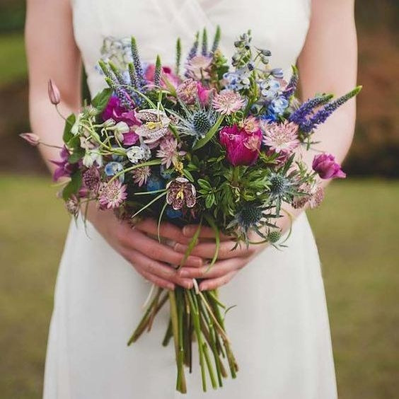 Quiet arrangement of cream and blush blooms with soft green foliage, photographed close up
