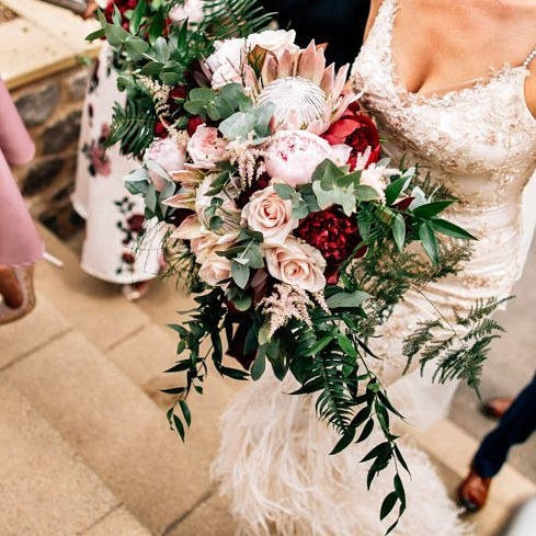 Close detail of flowers, herbs and wild foliage in a compote arrangement