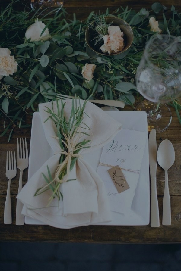 Tall decor feature of seasonal blooms and trailing foliage at a wedding venue